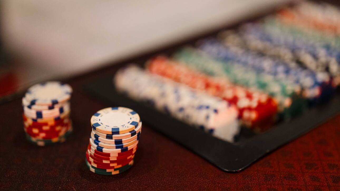 Stacks of colorful event chips sit in the foreground while organized chip trays blur into the background.