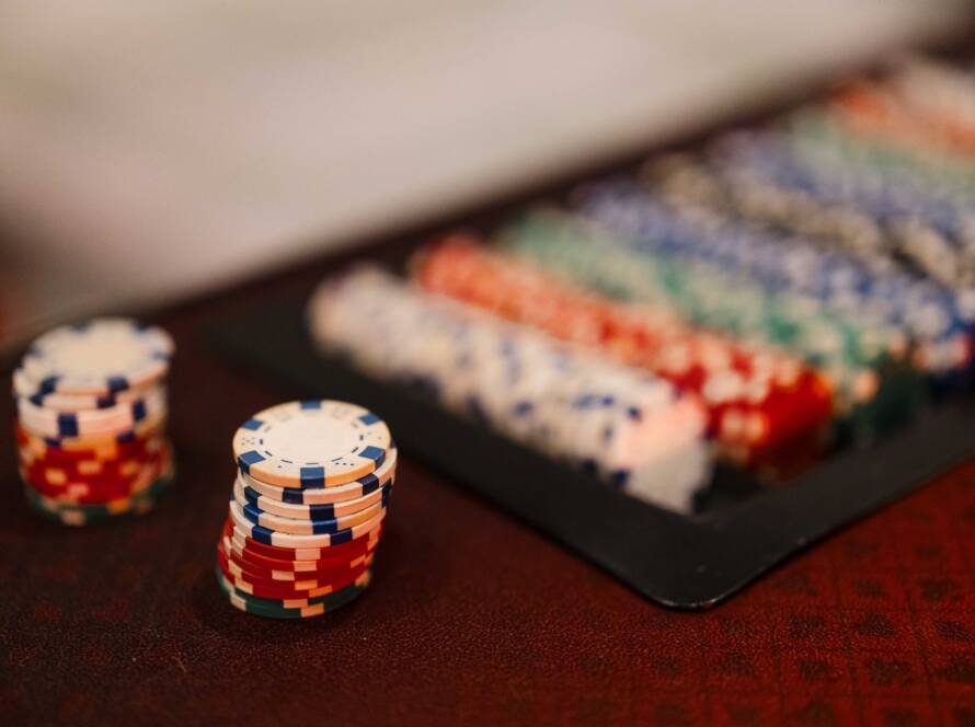 Stacks of colorful event chips sit in the foreground while organized chip trays blur into the background.